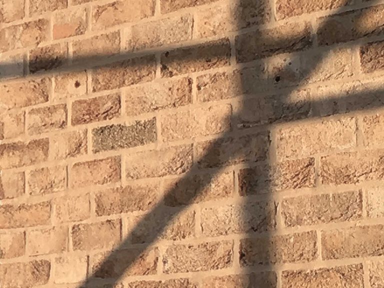 Brick detail with scaffolding casting shadow