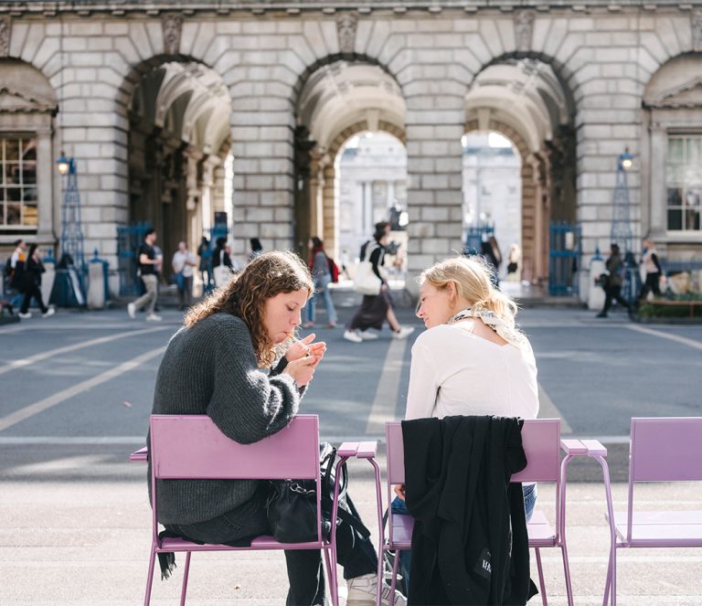 Two young people smoking in courtyard at Somerset House