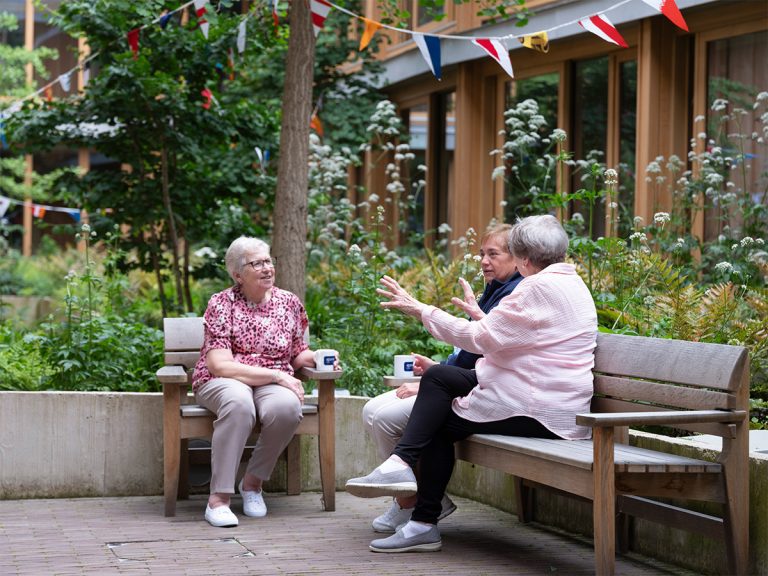 Elderly residents in couryard of Appleby Blue Almshouse
