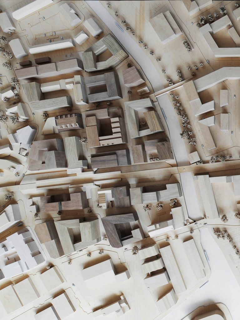 Masterplan model, with retained existing buildings in lighter wood: overview